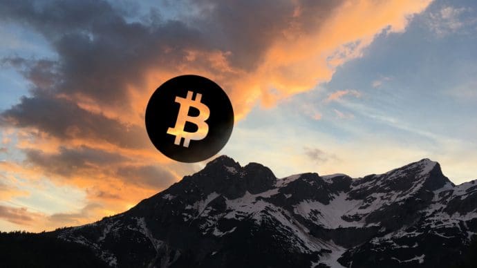 Een afbeelding van een bitcoin (BTC) munt boven een gebergte