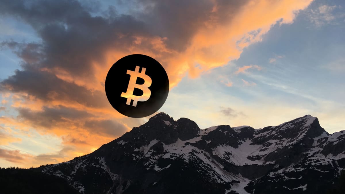 Een afbeelding van een bitcoin (BTC) munt boven een gebergte